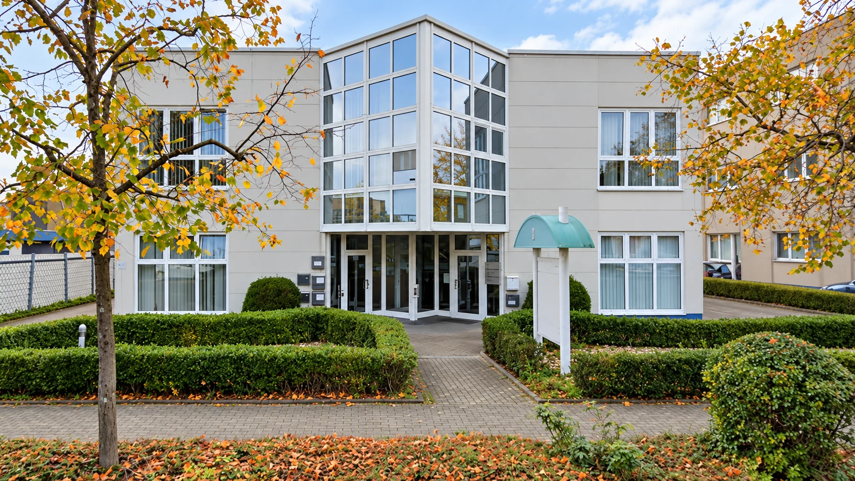 Gebäude am BoltCAD-Standort in Hilden bei Düsseldorf mit zentralem Eingangsbereich und herbstlichen Bäumen